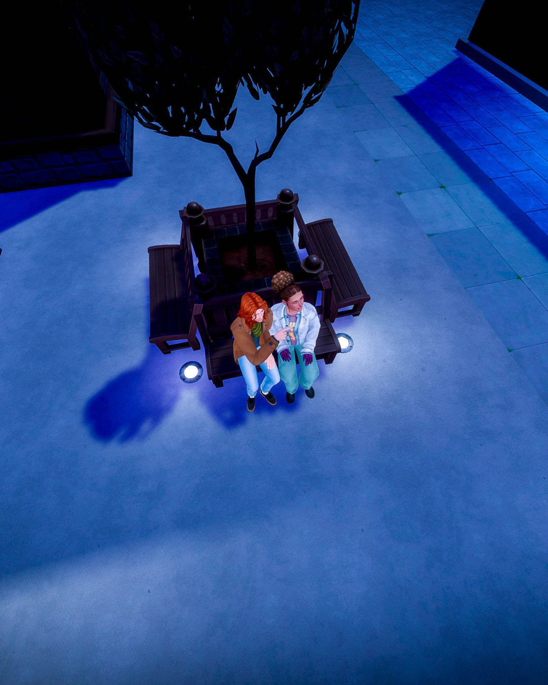 Jaime and Kristine sit on a bench at night looking at the stars.