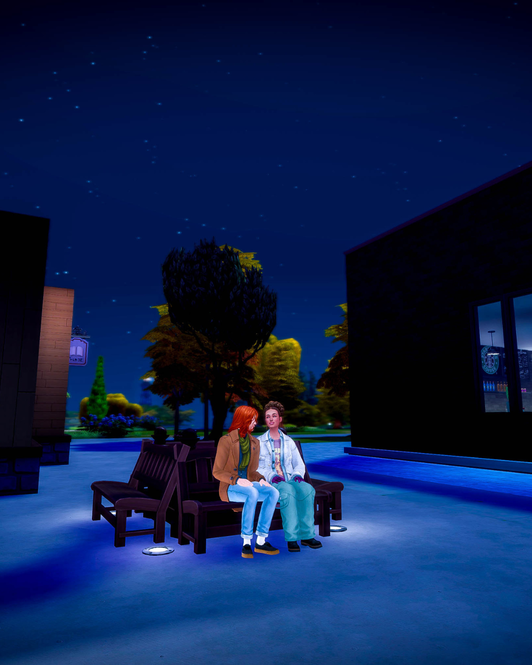 Jamie and Kristine sit on a bench outdoors at night, both looking very happy.