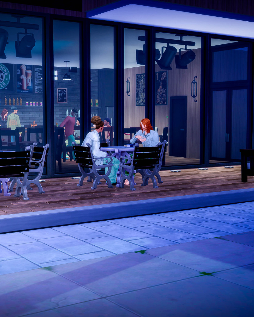 Jaime and Kristine have an intensly engaging conversation at their table in front of Starbucks at night.